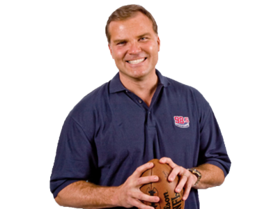 A cutout of Scott Zolak from the waist up holding a football and smiling at the camera.